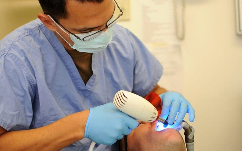 Dentist treating a patient with a curing light